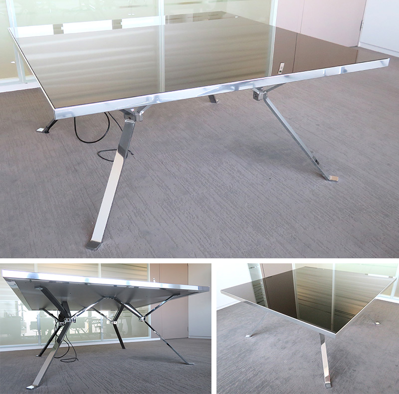 TABLE CARREE, PLATEAU EN BOIS RECOUVERT DE VERRE FUME ET ENCADREMENT EN ALUMINIUM REPOSANT SUR 4 PIEDS OBLIQUES EN ACIER CHROME. (PETITES RAYURES). 71 X 161 X 161 CM. 4A1 021